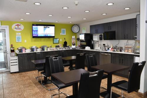 a restaurant with tables and a kitchen with a bar at Super 8 by Wyndham Fort McMurray in Fort McMurray