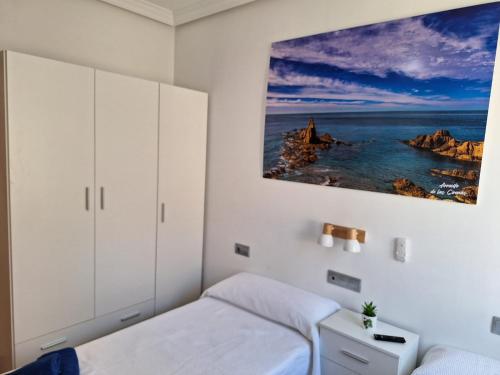 a bedroom with a bed and a painting on the wall at Apartamentos La Calilla Cabo de Gata in El Cabo de Gata