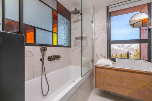 a bathroom with a shower and a sink and a window at Résidence LES CRISTAUX in Arc 1800