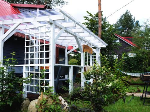 a white pergola in front of a house at Holiday Home near Lake Mausz with Sauna in Kłodno