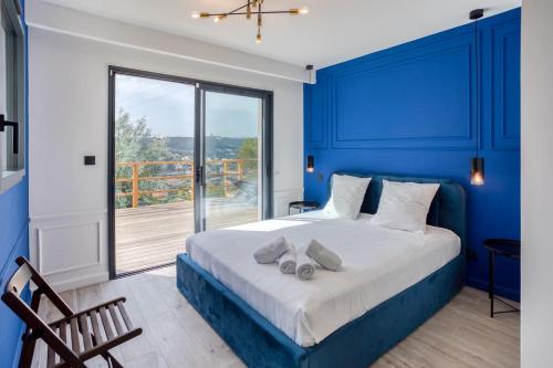 a blue bedroom with a bed and a large window at Villa modern Super-Cannes heated Pool, Parking, CLIM, 7 min to Cannes Beach in Vallauris