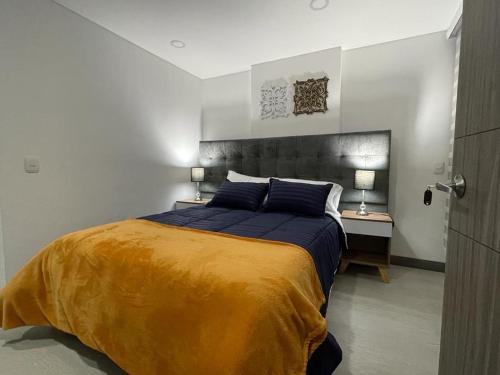 Magnifico y confortable apartamento amoblado # 303 في بوغوتا: غرفة نوم بسرير كبير ومصباحين