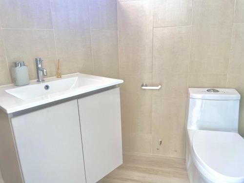 een badkamer met een witte wastafel en een toilet bij Apartamento con hermosa vista in Manta
