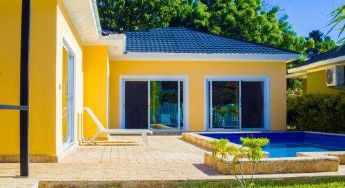 a yellow house with a pool in front of it at Amber Villa Malindi in Malindi
