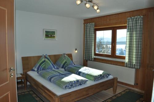um quarto com uma cama com almofadas e uma janela em Haashof em Vordergöriach
