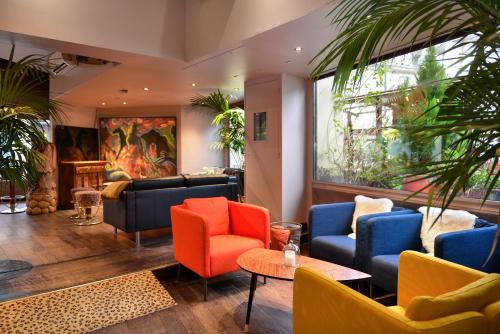 a lobby with colorful chairs and a table at Logis Hôtels Le Saint Georges in Vendôme