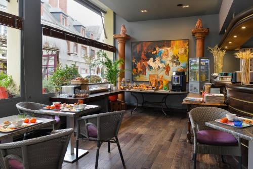 a restaurant with tables and chairs and a counter at Logis Hôtels Le Saint Georges in Vendôme