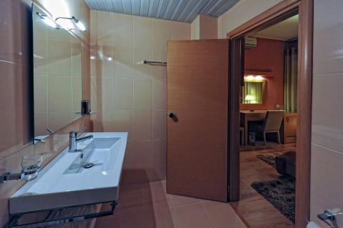 La salle de bains est pourvue d'un lavabo et d'un miroir. dans l'établissement Haikos Hotel, à Kalamata