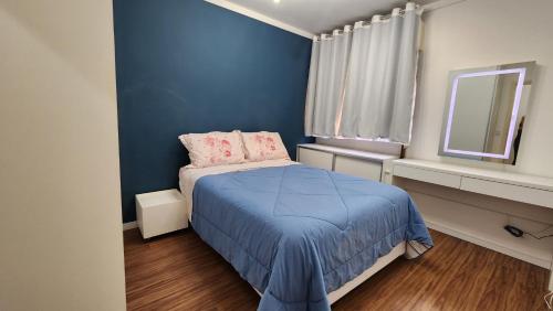 een blauwe slaapkamer met een bed en een raam bij UrbanComfort Apt Fradique Coutinho SP in Sao Paulo
