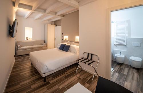 a bedroom with a bed and a bathroom with a tub at LE TORRI LOVERE in Lovere
