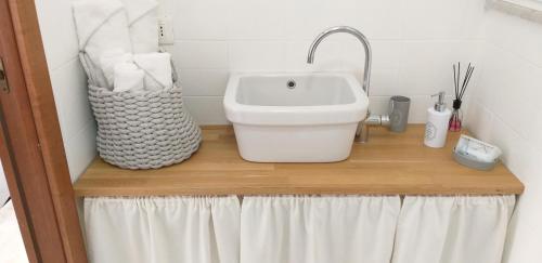 a bathroom with a sink on a wooden shelf at Aa Ciasèa duu Pintùu in Riomaggiore