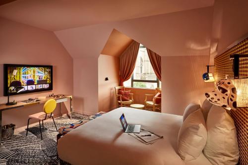 a hotel room with a couch and a tv at Mama Shelter Dijon in Dijon