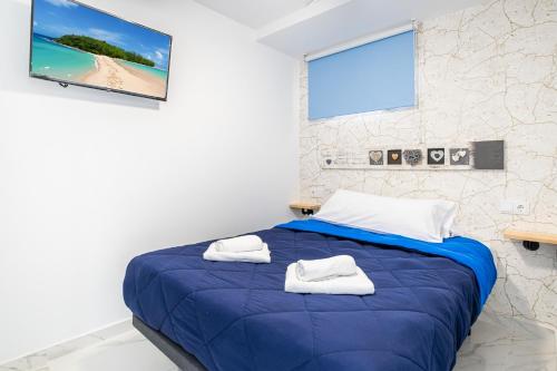 ビリャホヨサにあるEurotennis Paradise Beach Apartmentsのベッドルーム1室(ブルーベッド1台、タオル付)
