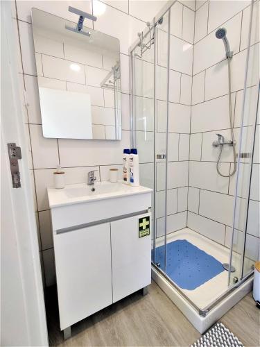 a bathroom with a sink and a shower at Funchal Apartments - New Botanic Garden Petit Studios in Funchal