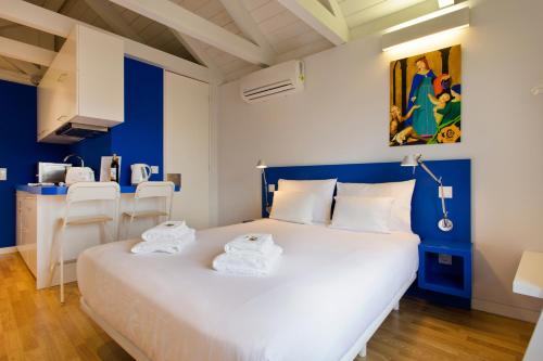 a bedroom with a large white bed with blue walls at Downtown Cosy Suite VI in Porto