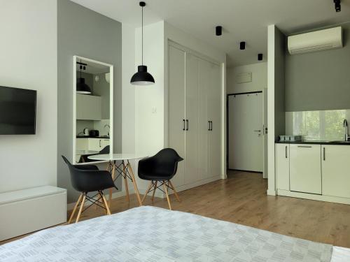 a bedroom with a bed and a table and chairs at Chopin Apartments Expo in Warsaw