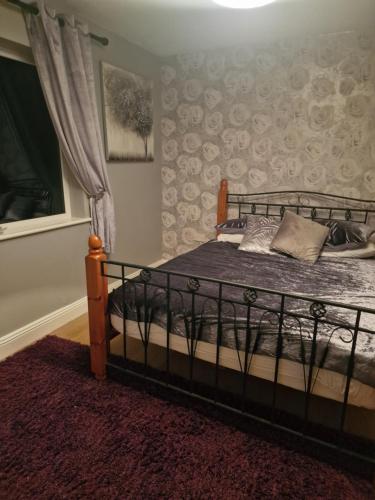 a bedroom with a bed with a wrought iron frame at Shanadune in Tralee