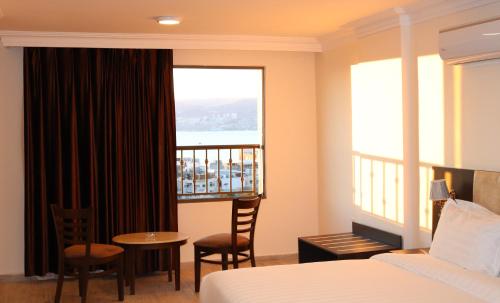a hotel room with a bed and a balcony at AQABA COAST HOTEL in Aqaba