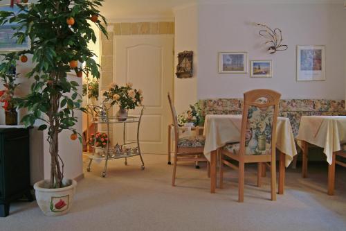 a dining room with a table and chairs and a plant at Landhaus Heide in Schneverdingen