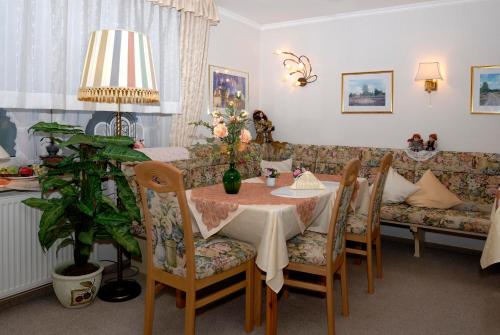 a dining room with a table and a couch at Landhaus Heide in Schneverdingen
