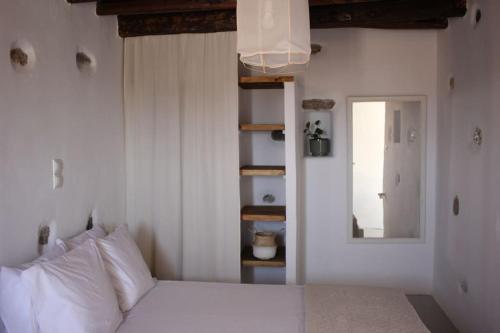 a bedroom with a white bed and a mirror at A casa d’ Irene in Kampos Paros