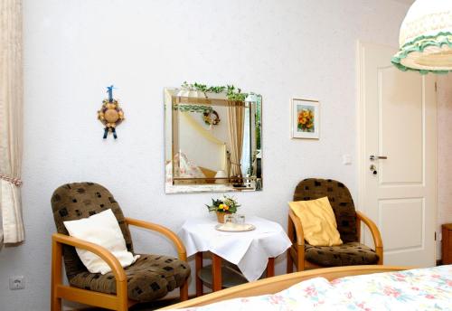 a bedroom with a table and two chairs and a mirror at Landhaus Heide in Schneverdingen
