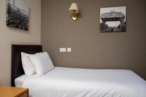 a bedroom with two beds and two pictures on the wall at Old Grey Mare Inn by Greene King Inns in Hull