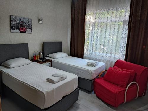 イスタンブールにあるFatih Hotel Erciyesのベッド2台と赤い椅子が備わるホテルルームです。