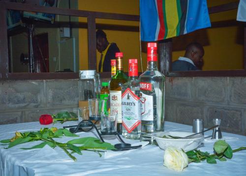 una mesa con botellas de alcohol encima en Caphill Hotel, en Syokimau