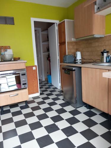 a kitchen with a black and white checkered floor at Au coteau des Thermes in Saint-Honoré-les-Bains