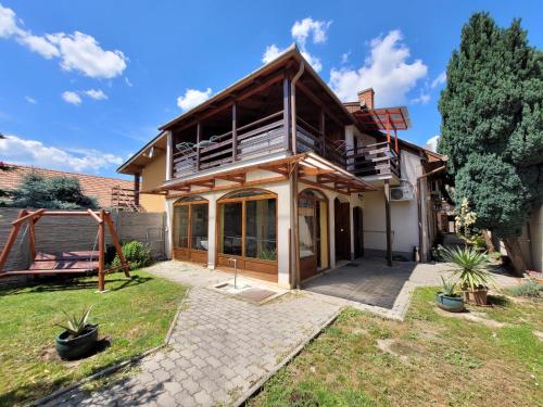 a house with a balcony and a yard at Penzión Korzo in Štúrovo