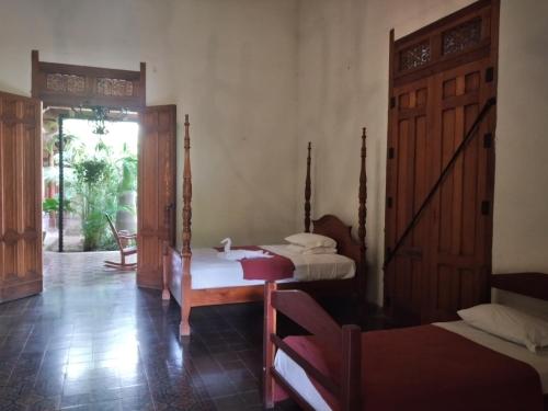 een slaapkamer met 2 bedden en een deur met een raam bij Backpackers Inn in Granada