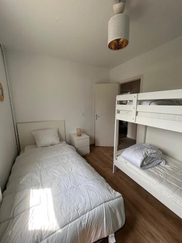 um quarto com uma cama e um beliche em Maison Saint Michel em Cabourg
