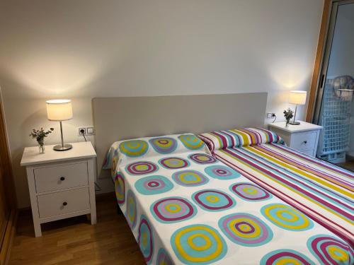 ポルト・デ・エスパサンデにあるApartamentos Galicia Norteのベッドルーム1室(大型ベッド1台、カラフルな掛け布団付)