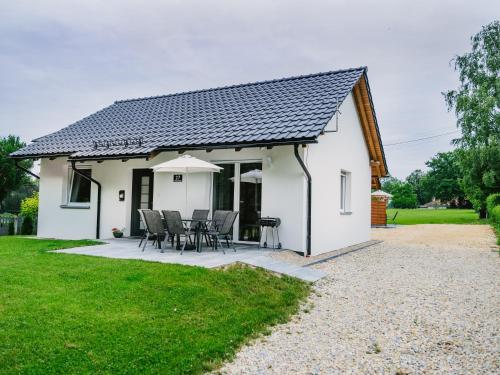 Cabaña blanca con mesa y sillas en Domek Moszna, en Moszna