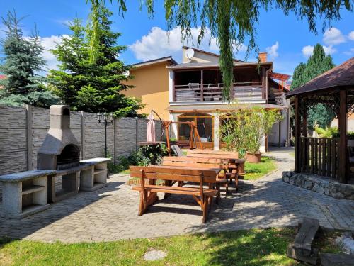 a group of picnic tables in front of a house at Penzión Korzo in Štúrovo