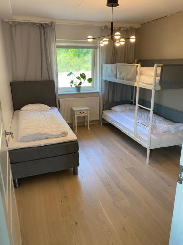 a bedroom with two bunk beds and a window at Tallhöjden - Stor villa med bastu! in Svärtinge