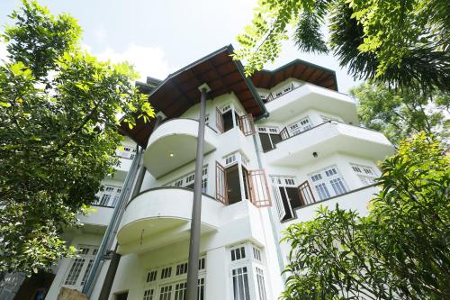 a large white building with a brown roof at Crown hills kandy in Kandy