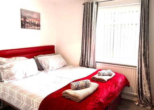 ein Bett mit zwei Kissen darauf in einem Schlafzimmer in der Unterkunft Spacious 3 Bedroom House - Sleeps 5 in Manchester