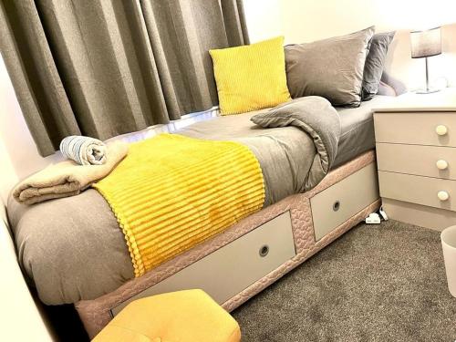 a bed with a yellow blanket on it in a room at Spacious 3 Bedroom House - Sleeps 5 in Manchester