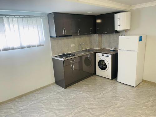 a kitchen with a refrigerator and a washing machine at Apart-Hotel Vasilisa EVN Airport in Pʼarakʼar