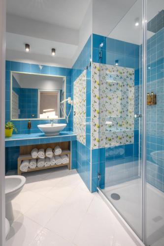 a blue bathroom with a shower and a sink at Mia Resort Paestum in Paestum