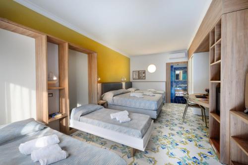 a hotel room with two beds and a desk at Mia Resort Paestum in Paestum