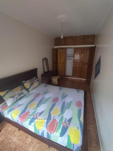 1 dormitorio con 1 cama con un edredón colorido en Maison en lieu calme en El Jadida