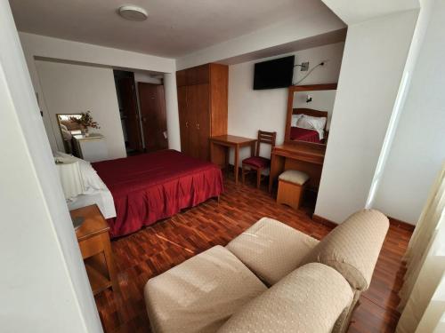 Habitación de hotel con cama y sofá en Hotel Oceano Mit en Tacna