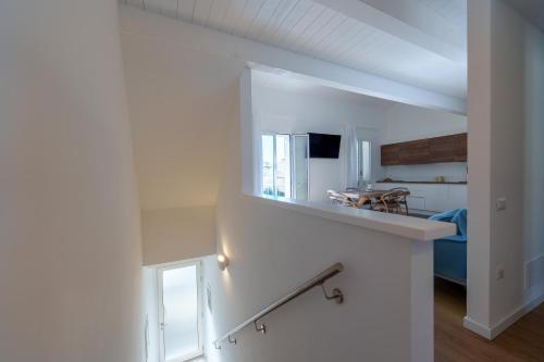 a white room with a staircase with a mirror at Appartamento Rena Bianca in Santa Teresa Gallura