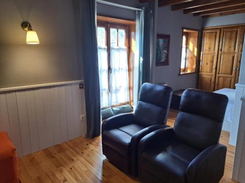ein Wohnzimmer mit einem Sofa und einem Stuhl in der Unterkunft Apartamento con encanto in Pla de l'Ermita