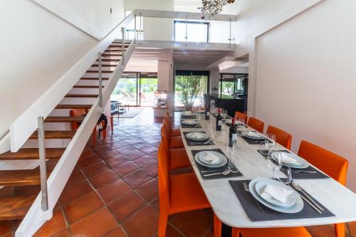 une salle à manger avec une grande table et des chaises orange dans l'établissement Villa Wine & Roses, à Libourne