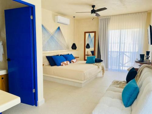 - un salon avec un lit et une porte bleue dans l'établissement Sunsteps suite pyramids, à Holbox