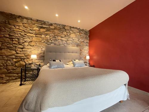 ユリューニュにあるChambres d'hôtes MANTTUの石壁のベッドルーム1室(大型ベッド1台付)